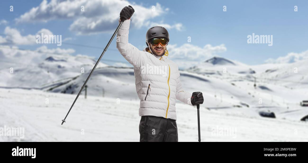 Man with skis lifting a skiing pole on a mountain Stock Photo