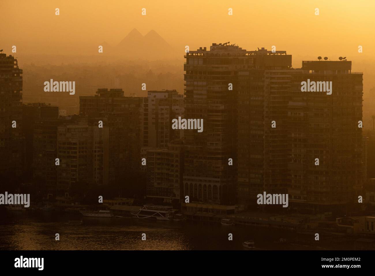 The pyramids at Giza seen through the afternoon light from a tall building in Cairo, Egypt Stock Photo