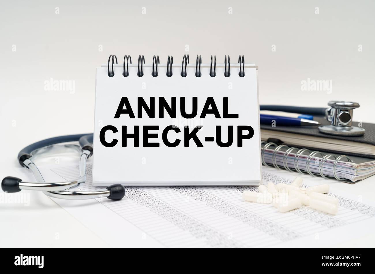 Check Up Notebook Medicine and health concept. On the table is a stethoscope, a diary and ...