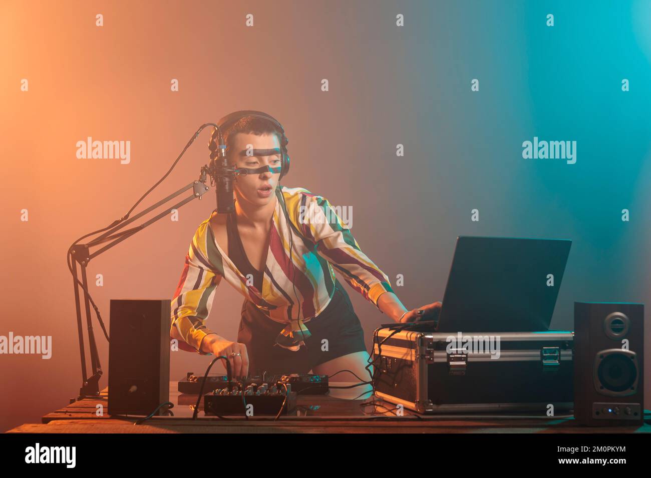 Female artist mixing techno music with turntables, musical performer