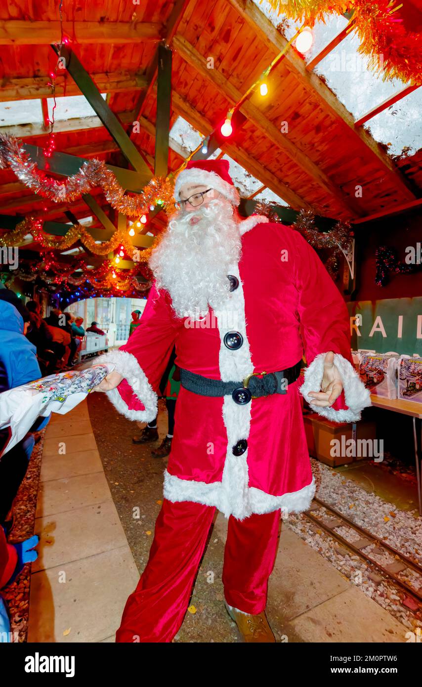 Santa Claus giving presents at the annual Santa Special event at Mizens Railway in Woking, Surrey, an event with miniature train rides for children Stock Photo