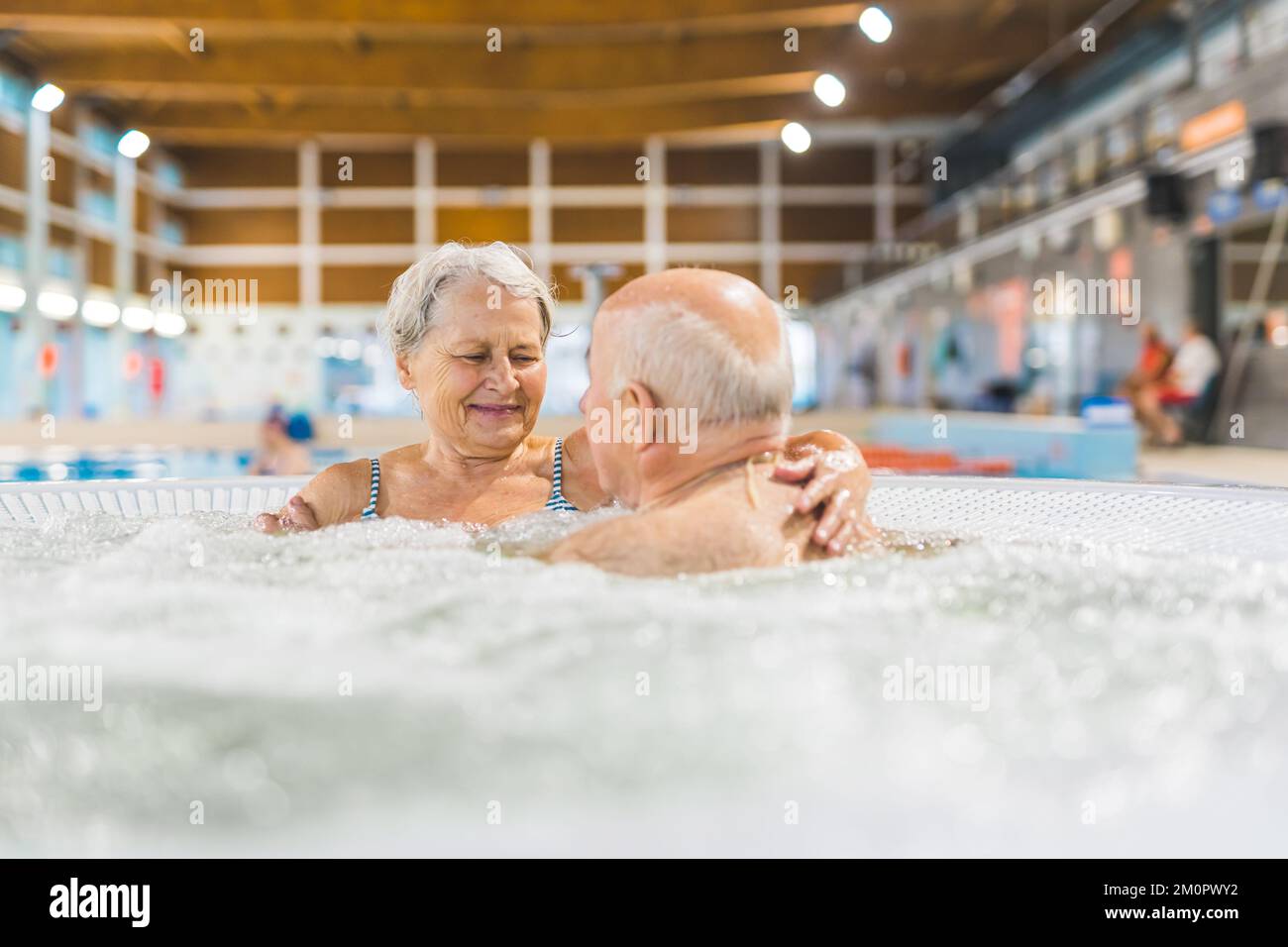 Indoor portrait of two happy caucasian grandparents relaxing in a bath