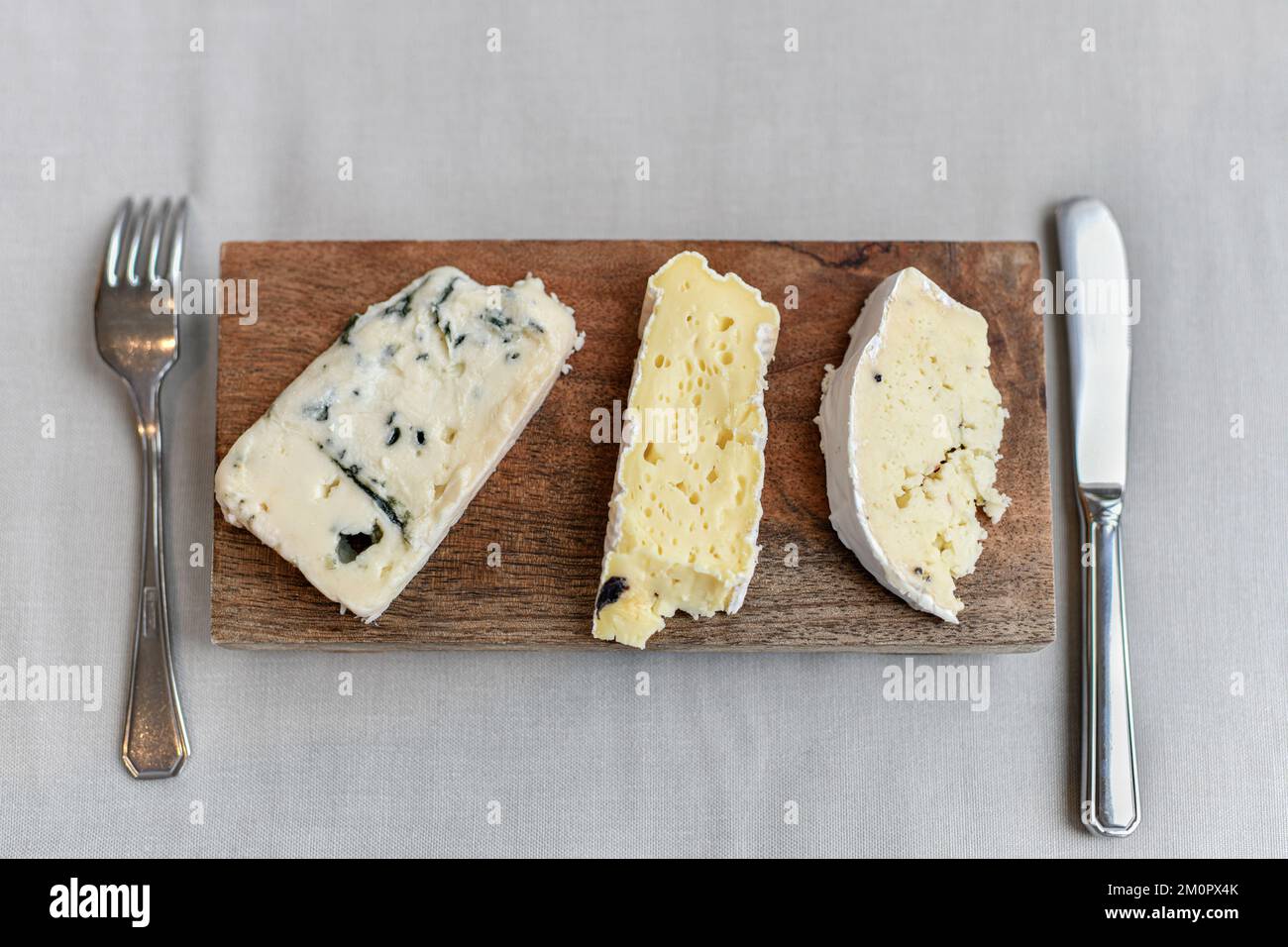 French cheese on a wooden board in restaurant Stock Photo