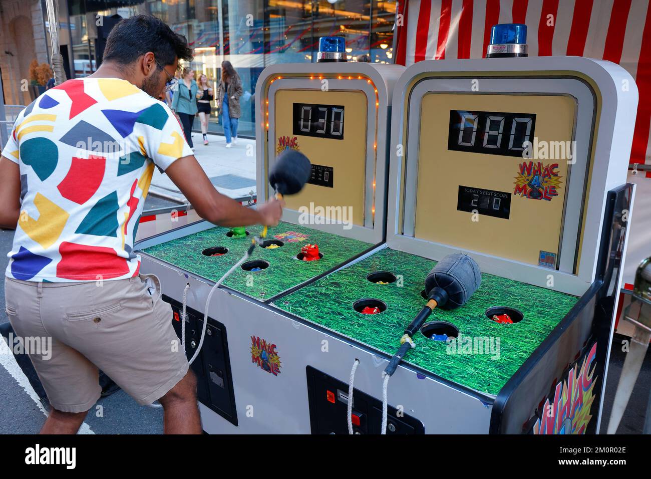 A person plays Whac-a-Mole, a carnival game originally invented in Japan as Mogura Taiji モグラ退治 or Mogura Tataki モグラたたき. whack a mole. Stock Photo