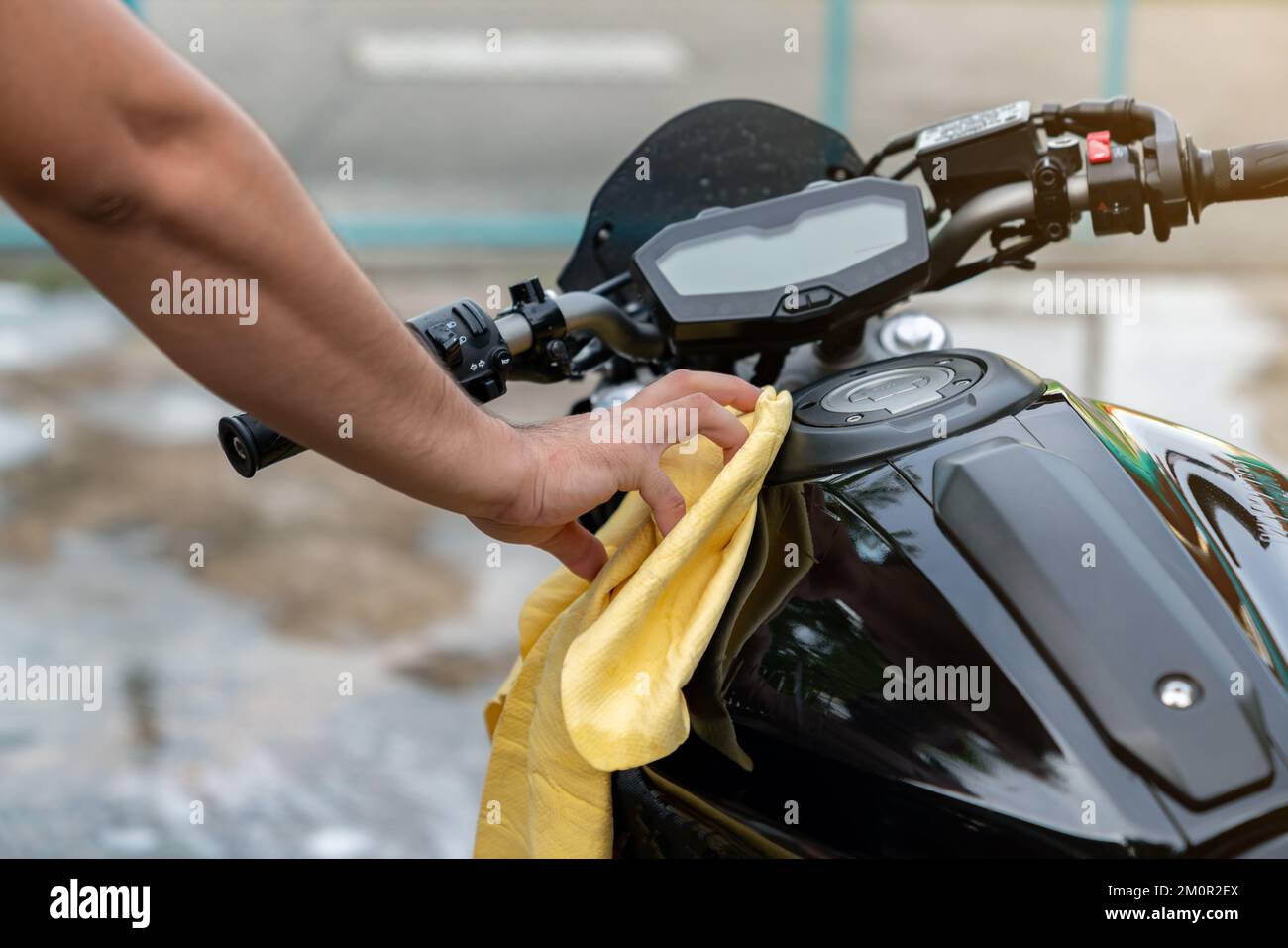 Motorcycle clean, youngman hand with yellow fabric washing a motorcycle