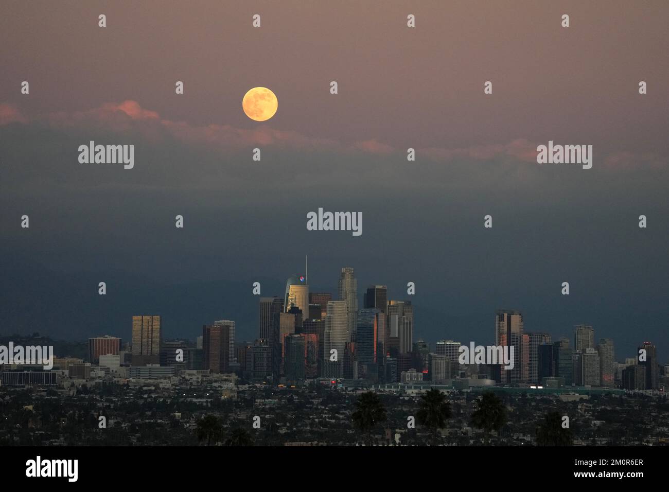 A full moon rises over the downtown Los Angeles skyline