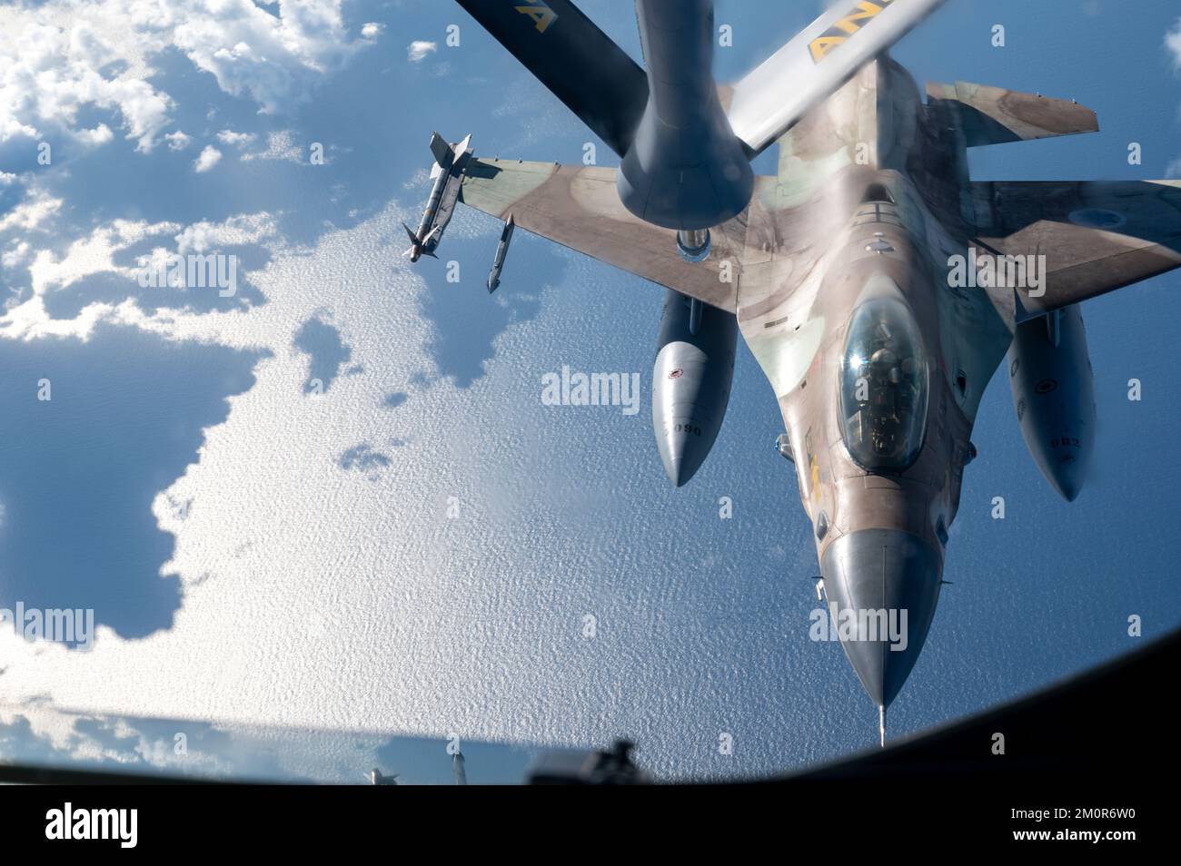 An Israeli Air Force F-16 Fighting Falcon prepares to receive refuel from a U.S. Air Force KC-135 Stratotanker assigned to the 340th Expeditionary Air Refueling Squadron, as part of a bilateral exercise over an undisclosed location in the U.S. Central Command area of responsibility, Nov. 30, 2022. The exercise demonstrated fighter aircraft integration and escort as well as refueling operations as part of the first of several exercises to maintain the ironclad commitment and bilateral aerial capability between the U.S. and Israeli Air Forces. (U.S. Air Force photo by Staff Sgt. Kirby Turbak) Stock Photo