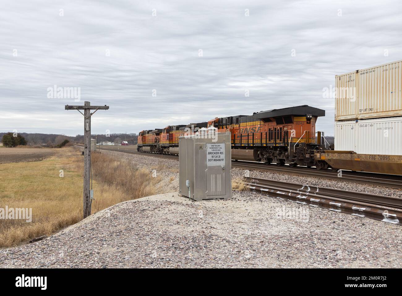 A BNSF freight train carrying double stack containers travels westbound across Lee County, Iowa Stock Photo