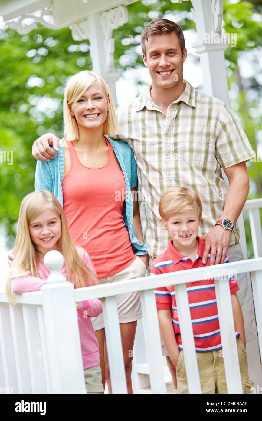 The perfect family portrait. A family of four standing together on their porch. Stock Photo