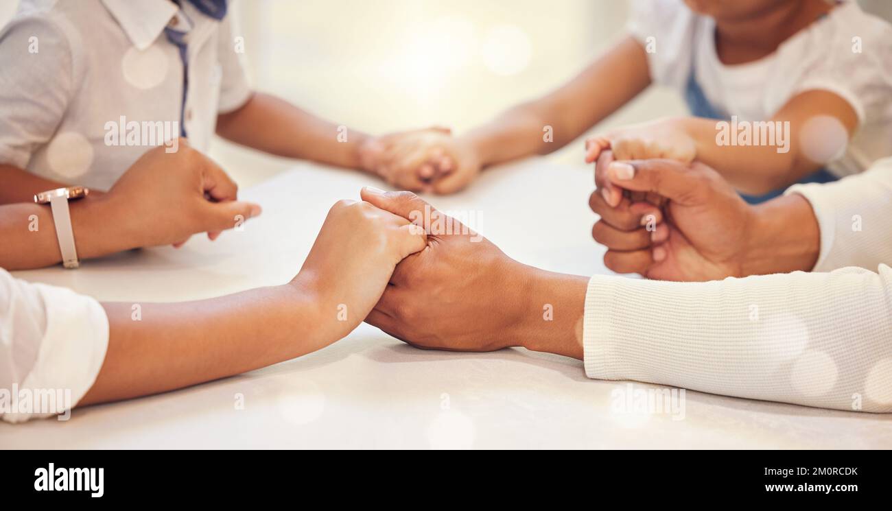 Close up of family holding hands in prayer while sitting at table. Parents and children saying grace. Thankful family show gratitude Stock Photo