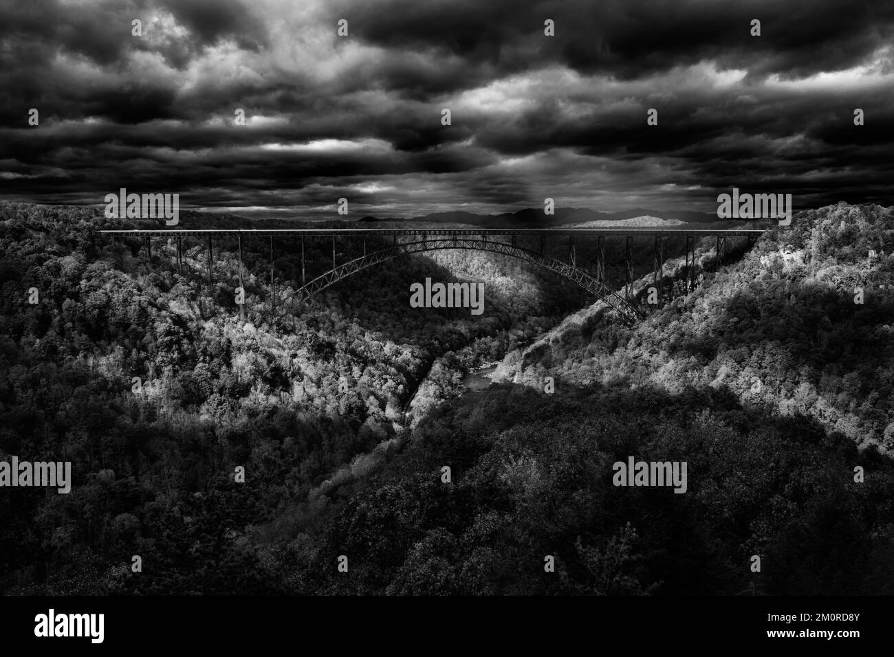 A grayscale view of the New River Gorge Bridge under a cloudy sky in Victor, Fayette County, West Virginia Stock Photo