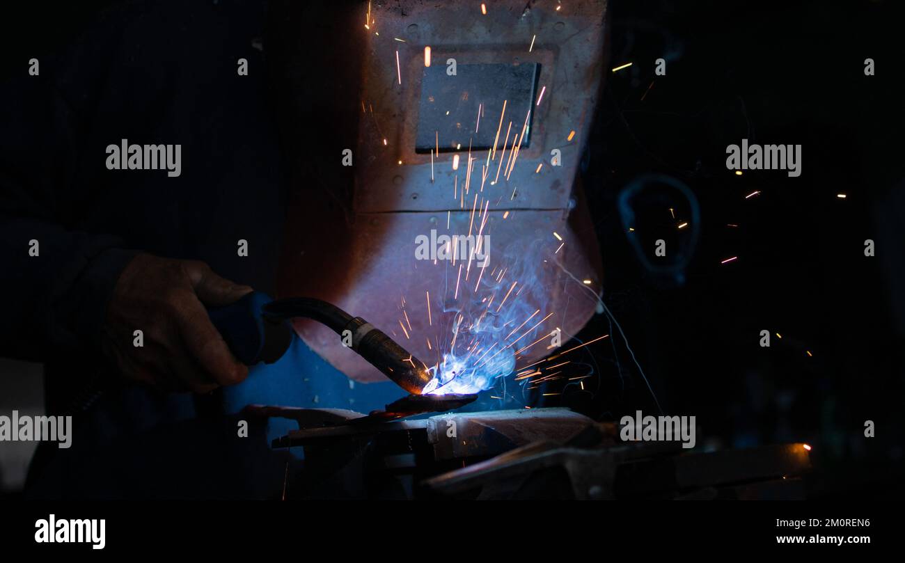 Welding of steel, sparking, not wearing gloves but with a protective