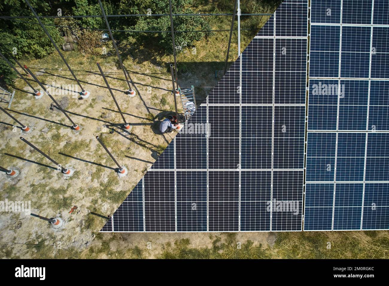 Photovoltaic solar panel fading away and shifting into metal supporting structure. Transition between solar module and metal poles in grassy field. Before and after concept. Stock Photo