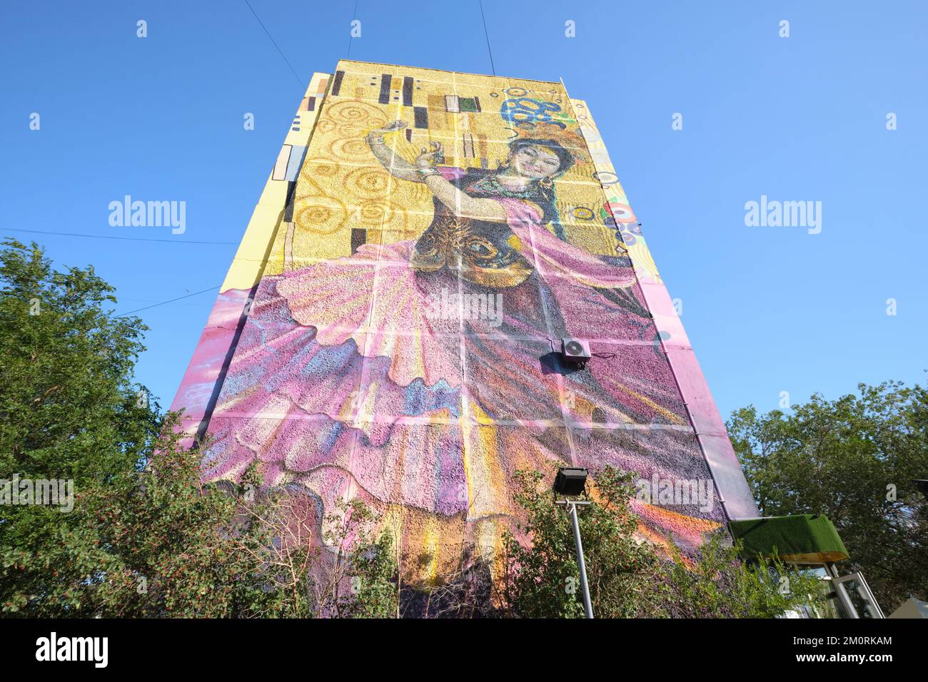 A giant painted mural on the end of a large apartment building
