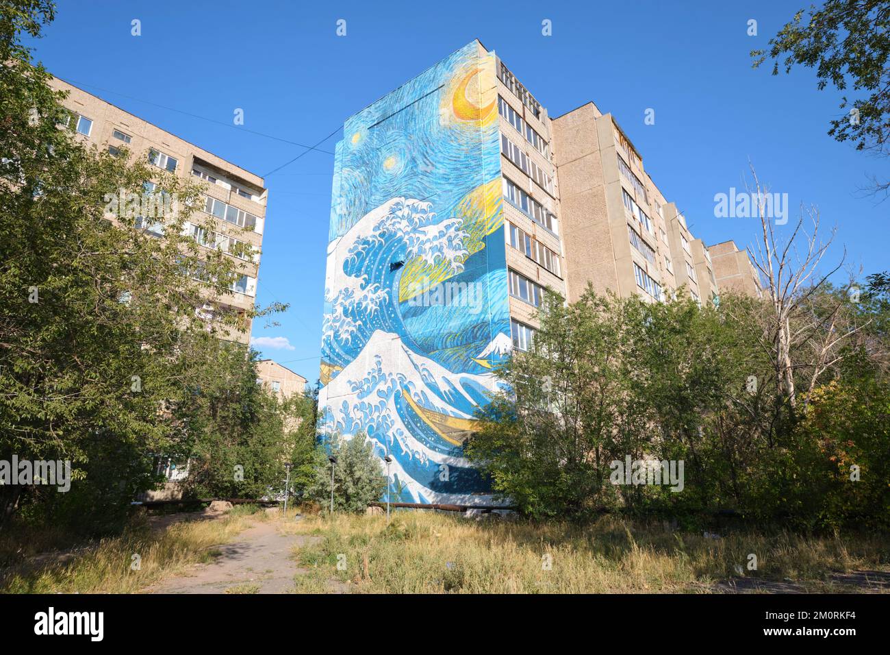 A giant painted mural on the end of a large apartment building