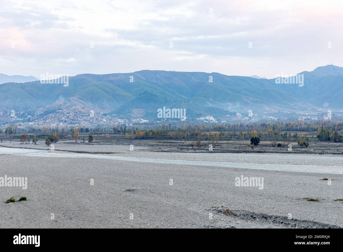 Agriculture fertile land washed away from flooding in the river leaving pebbles and stones Stock Photo