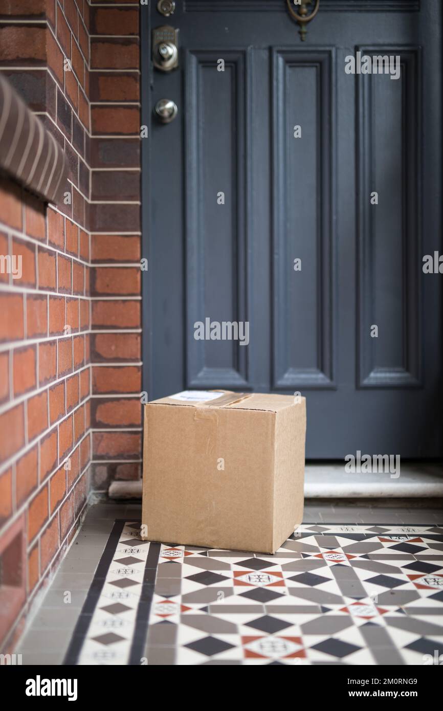 A vertical shot of a delivered package on the doormat Stock Photo