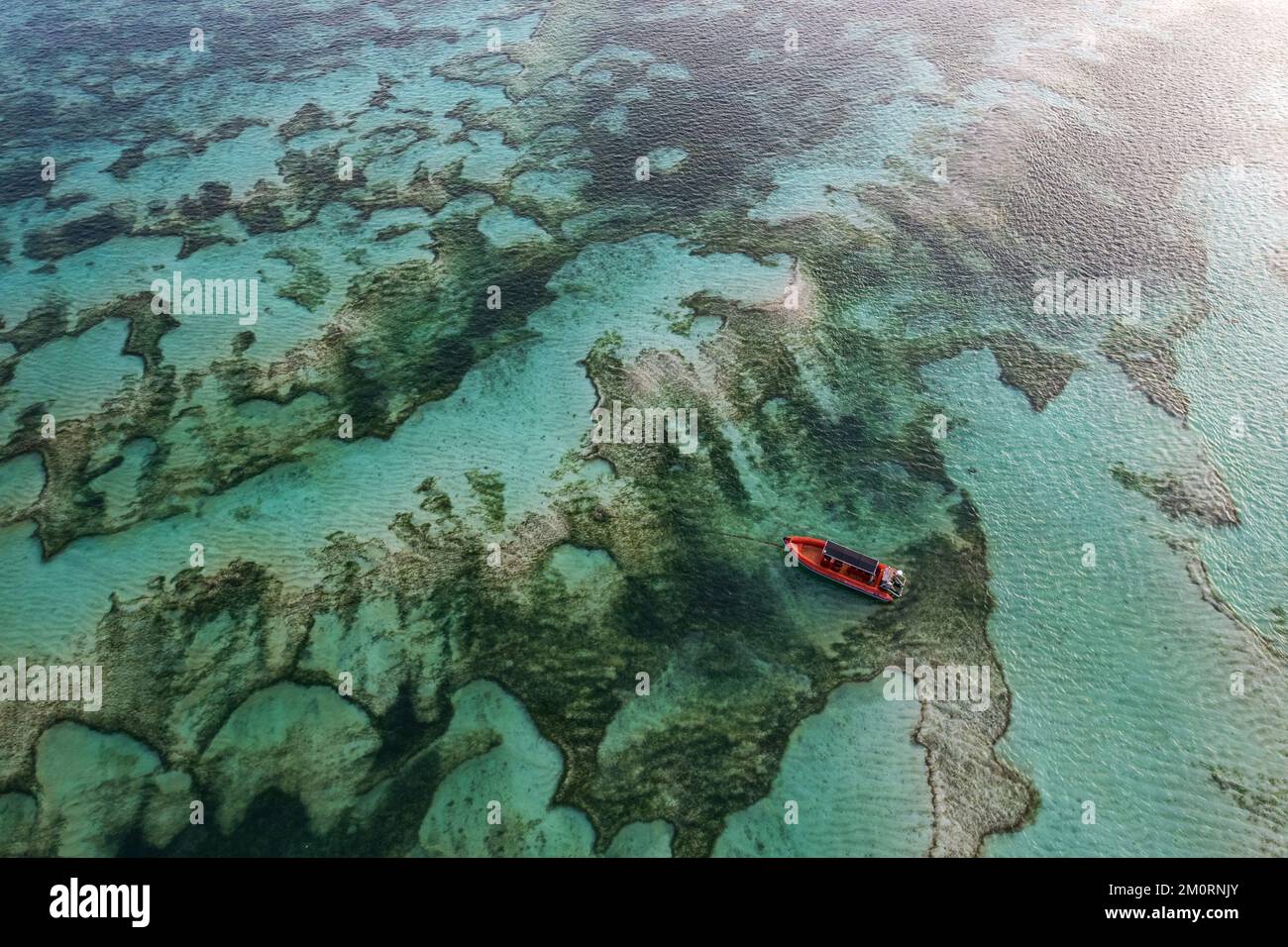 Aerial view of a red boat anchored over sand banks, Kuta Mandalika beach, Lombok, Nusa Tenggara, Indonesia Stock Photo