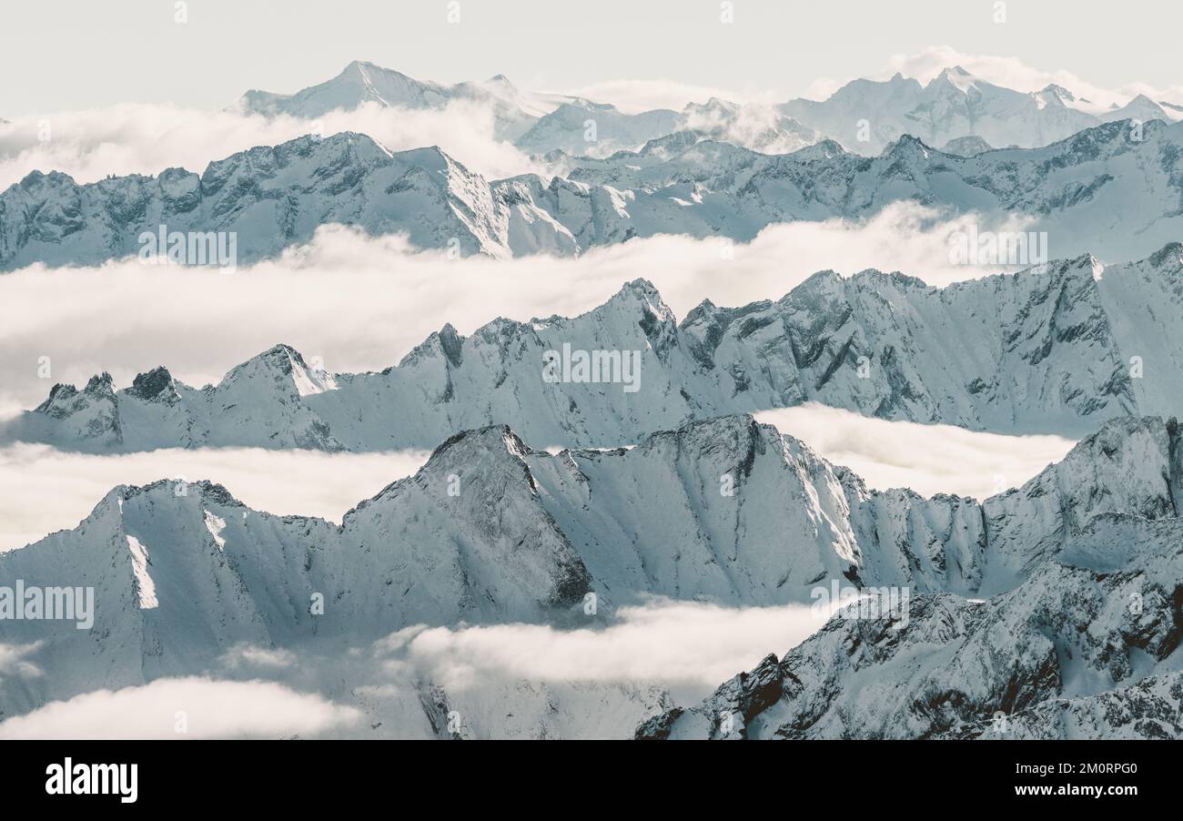 Aerial view of snowcapped mountain peaks through clouds, Hintertux glacier, Tyrol, Austria Stock Photo