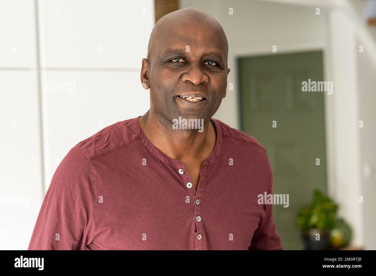 Portrait of senior African-American man standing in kitchen looking at camera Stock Photo