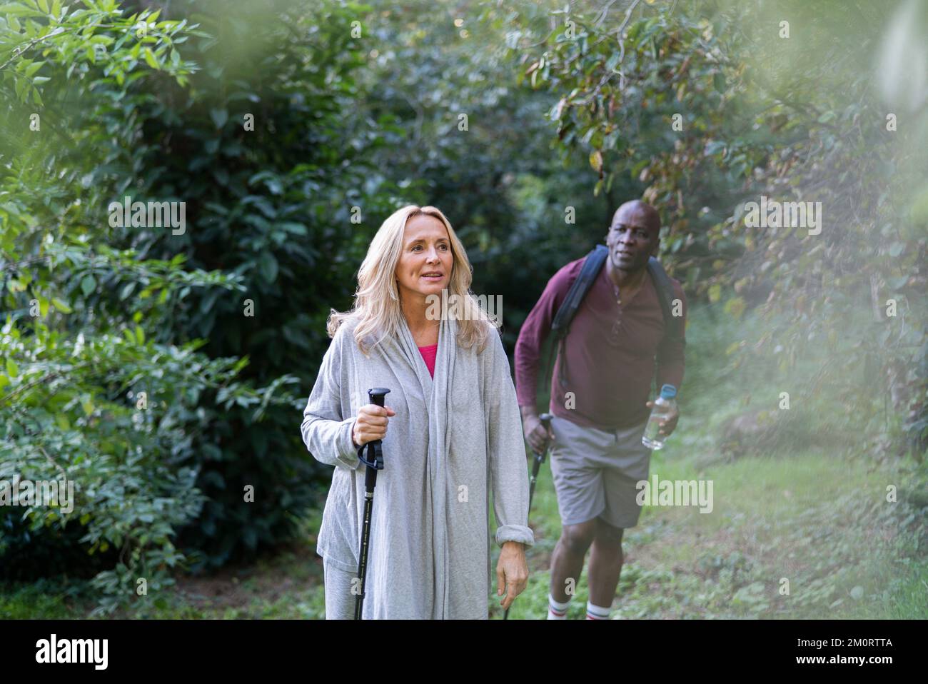 Senior couple doing hiking tour in the woods during daytime Stock Photo