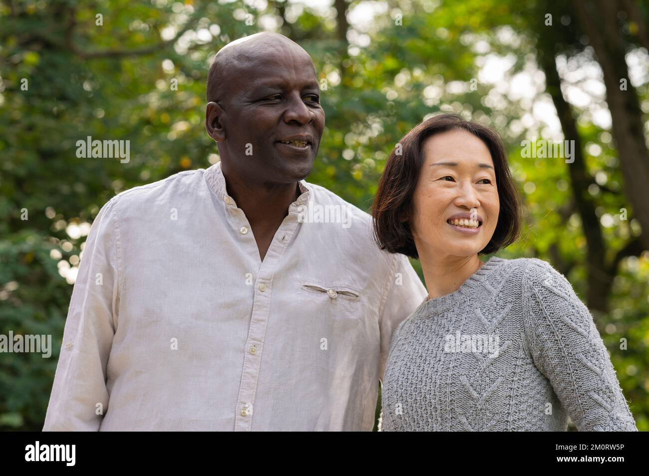 Middle-aged diverse couple hanging out inpublic park Stock Photo