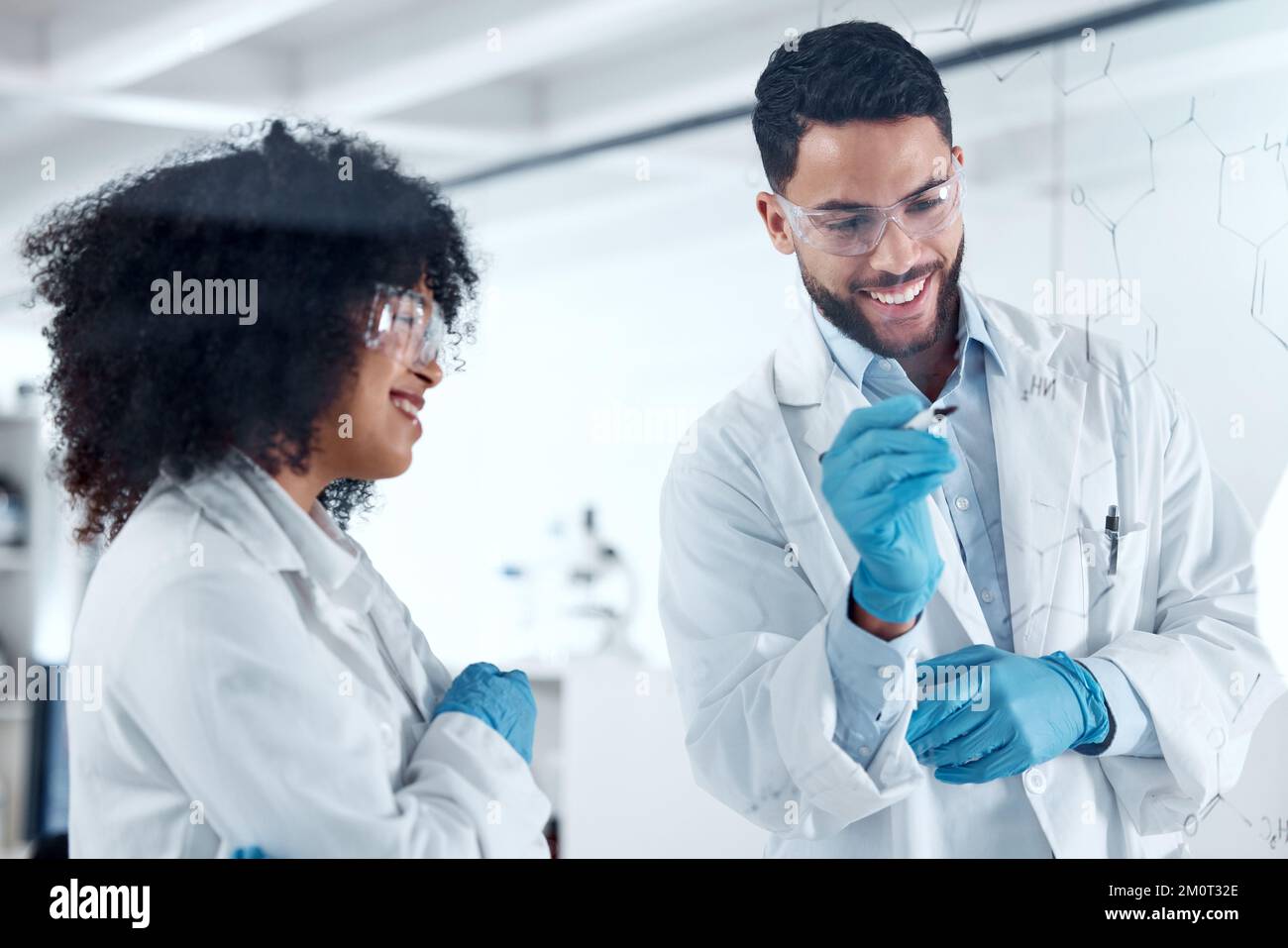 Two young science experts conducting a research experiment in the lab together. Two scientists collaborating, brainstorming during a meeting. Medical Stock Photo