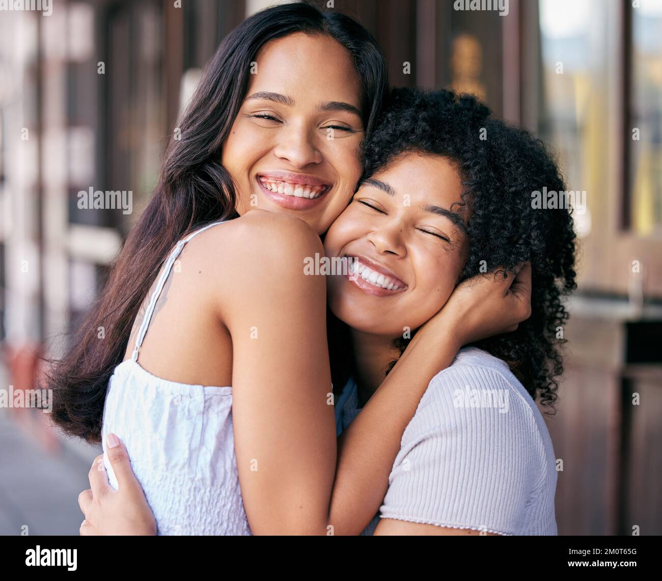 Friends, love and care with hug while bonding outside in the city during a summer trip. Bond, loving and caring friendship with cheerful women embrace Stock Photo