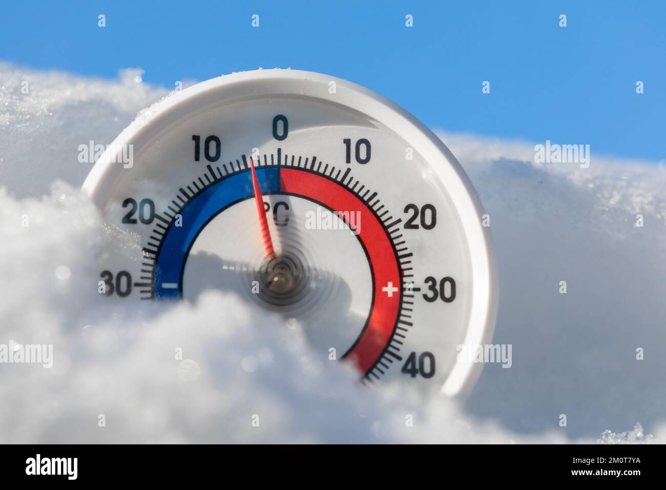 Thermometer with celsius scale in the snow showing minus 4 degree ambient temperature - winter weather concept Stock Photo