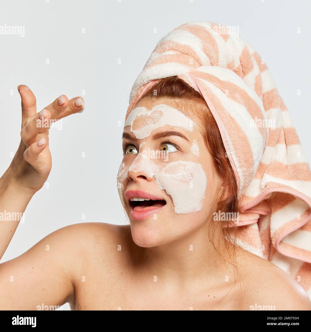 Portrait of young emotive woman with towel on head taking care after