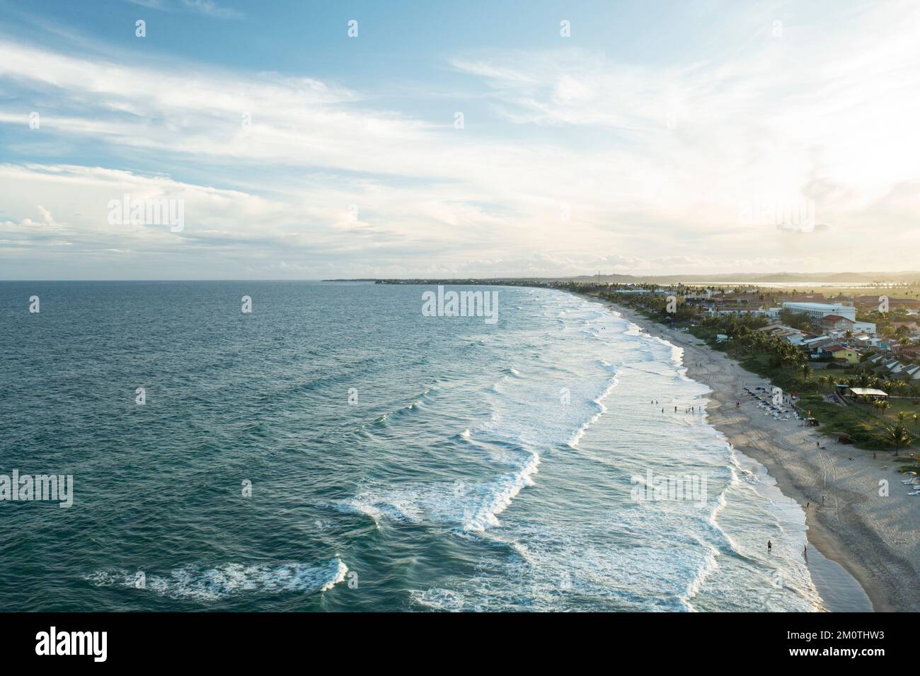 Porto de Galinhas, Pernambuco, Brazil - November 11, 2022 - Coconut trees in front of the beach with waves at dusk Stock Photo