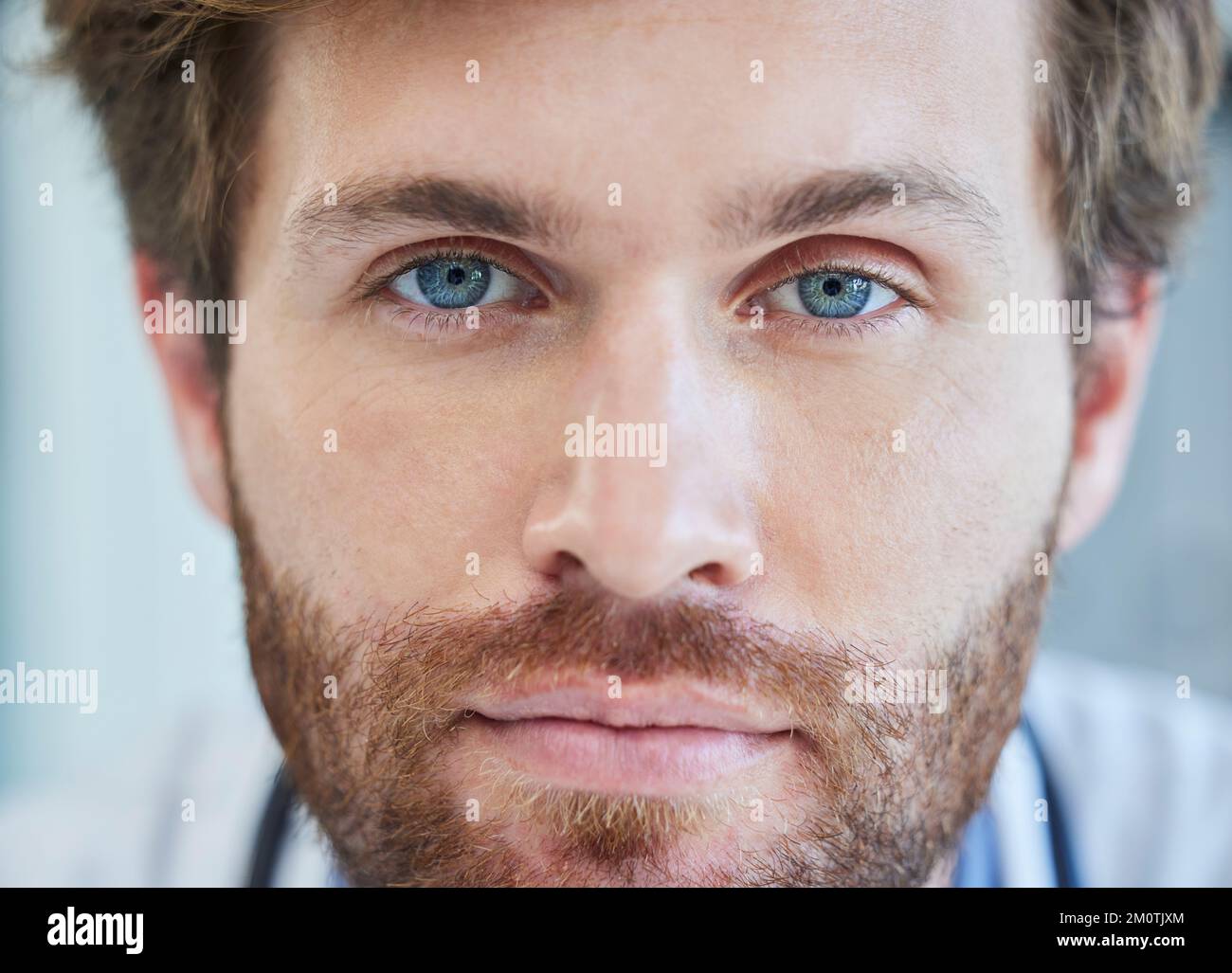 Doctor, face and blue eyes in healthcare, medical or surgeon with vision for insurance at the hospital. Closeup portrait of male nurse professional Stock Photo