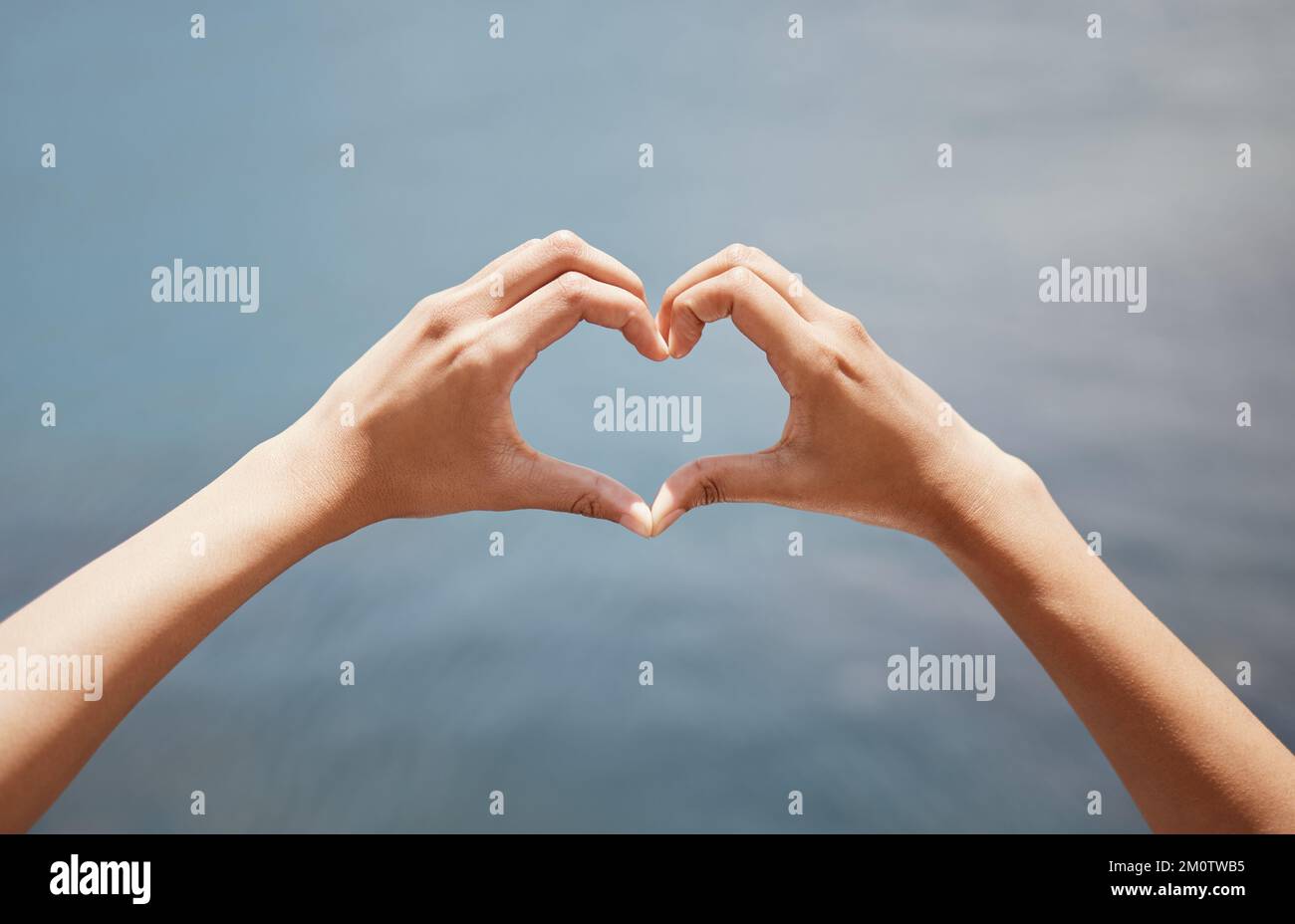 Where there is love, there is life. Closeup shot of an unrecognisable woman making a heart shape with her hands against a grey background. Stock Photo