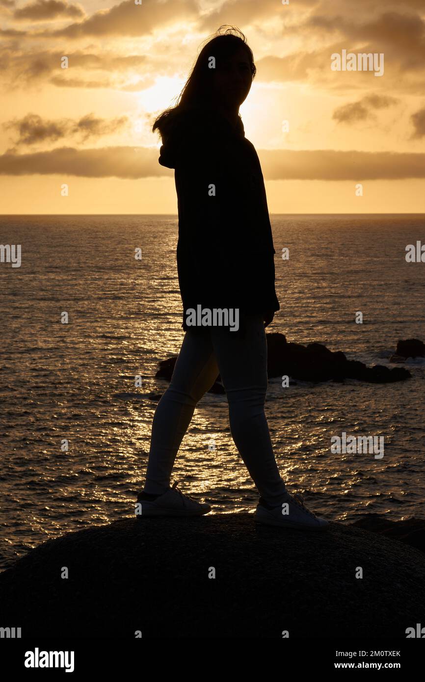 A silhouette of a woman near to the sea during sunset Stock Photo - Alamy