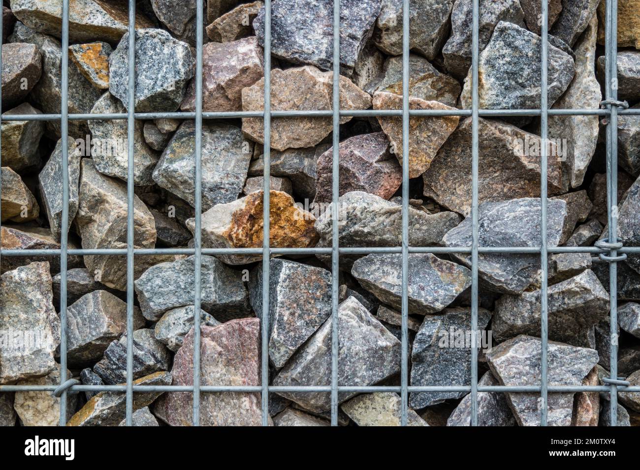 Natural stones with an iron grid Stock Photo - Alamy