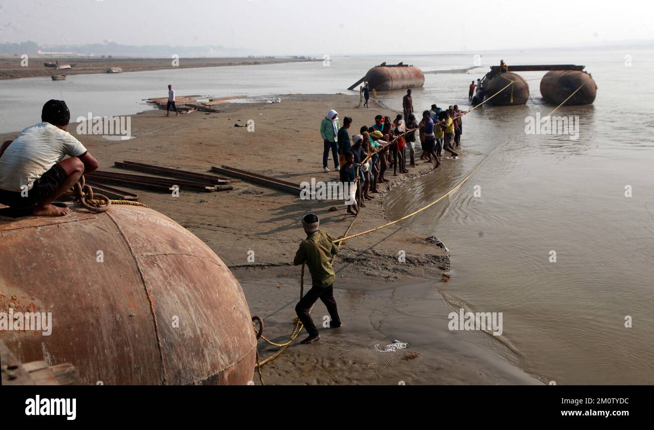 Prayagraj, India. 08/12/2022, Indian Labourers build a pontoon bridge on the Ganges River during preparations for the upcoming annual Hindu religious fair of Magh Mela in Prayagraj, India.  Credit: Anil Shakya/Alamy Live News Stock Photo