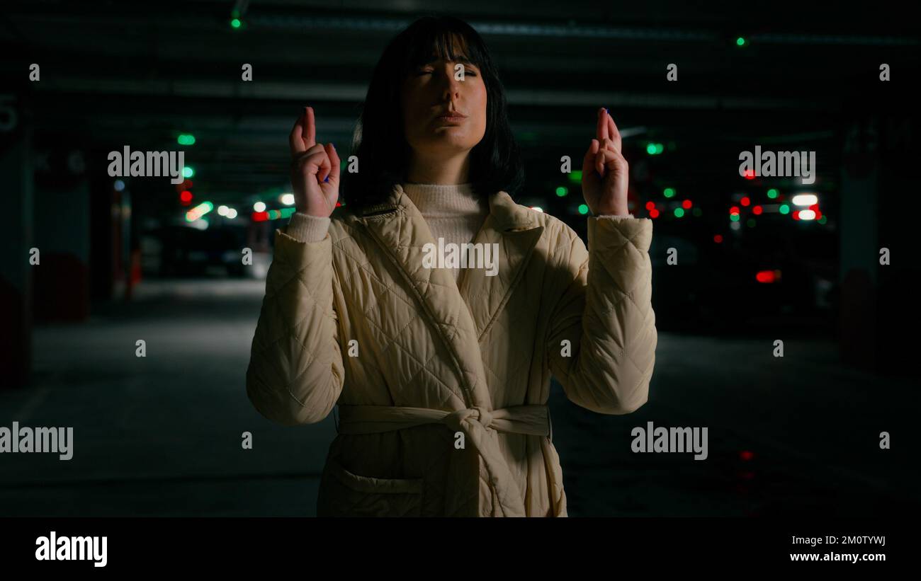 Lady female girl woman with closed eyes wish cross fingers pray for