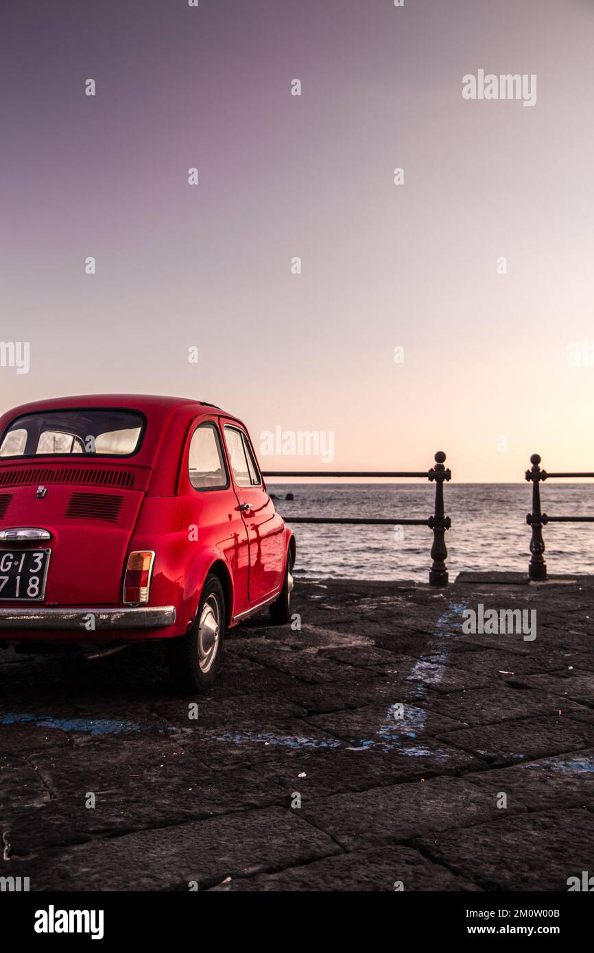 old red car parked by the sea Stock Photo
