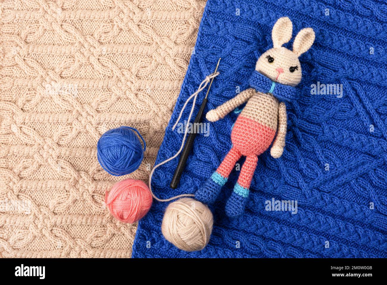 Knitted children's toy hare or bunny with a balls of thread and a ...