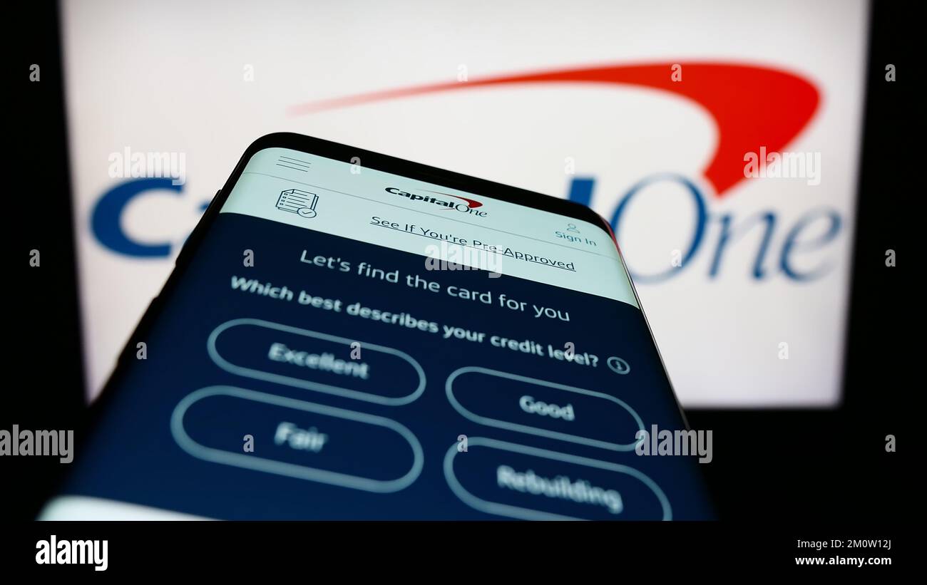 Smartphone with webpage of US company Capital One Financial Corporation on screen in front of webpage. Focus on top-left of phone display. Stock Photo