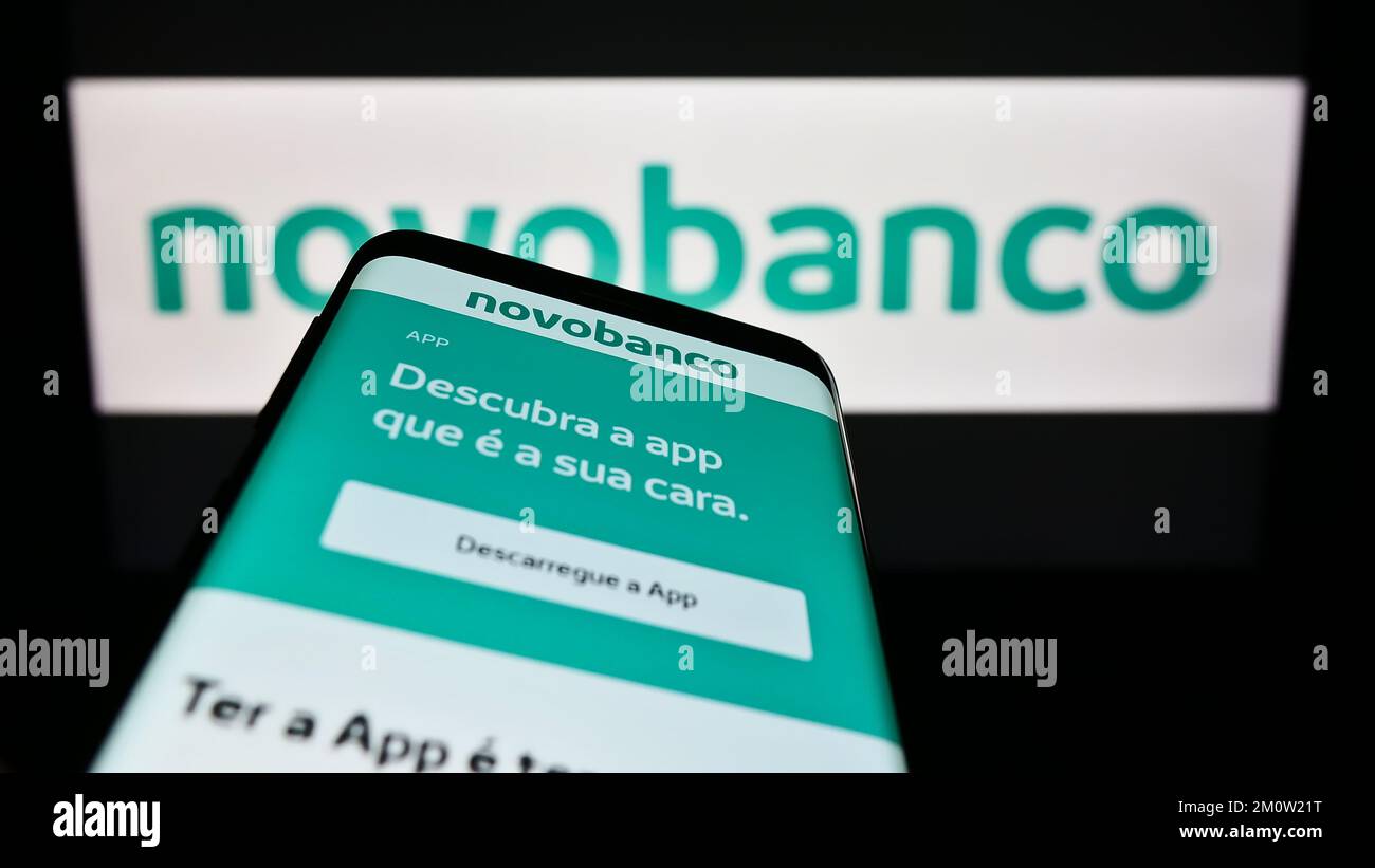 Smartphone with website of Portuguese banking company Novo Banco S.A. on screen in front of business logo. Focus on top-left of phone display. Stock Photo
