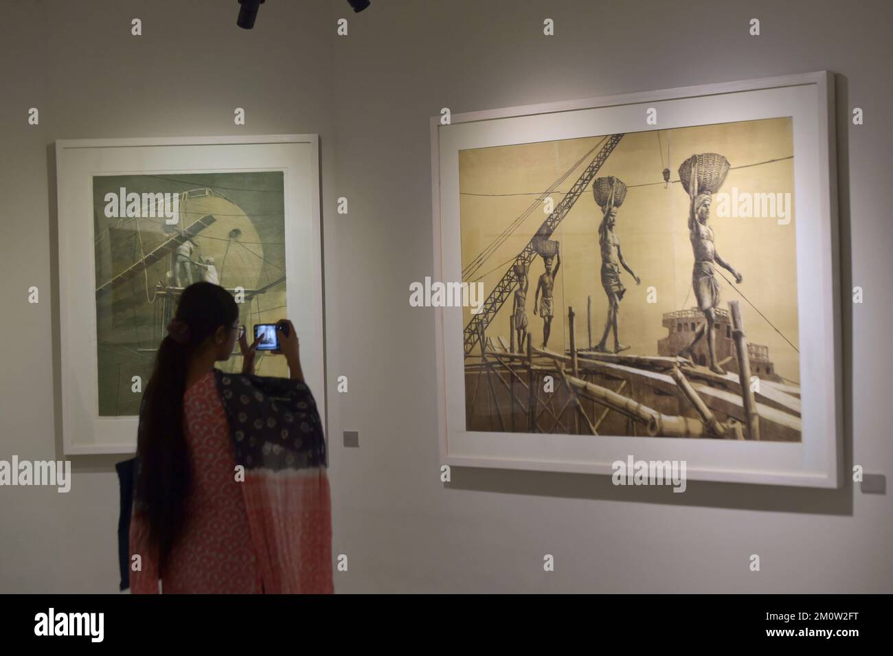 Dhaka. 8th Dec, 2022. A visitor takes photos of art works during an art