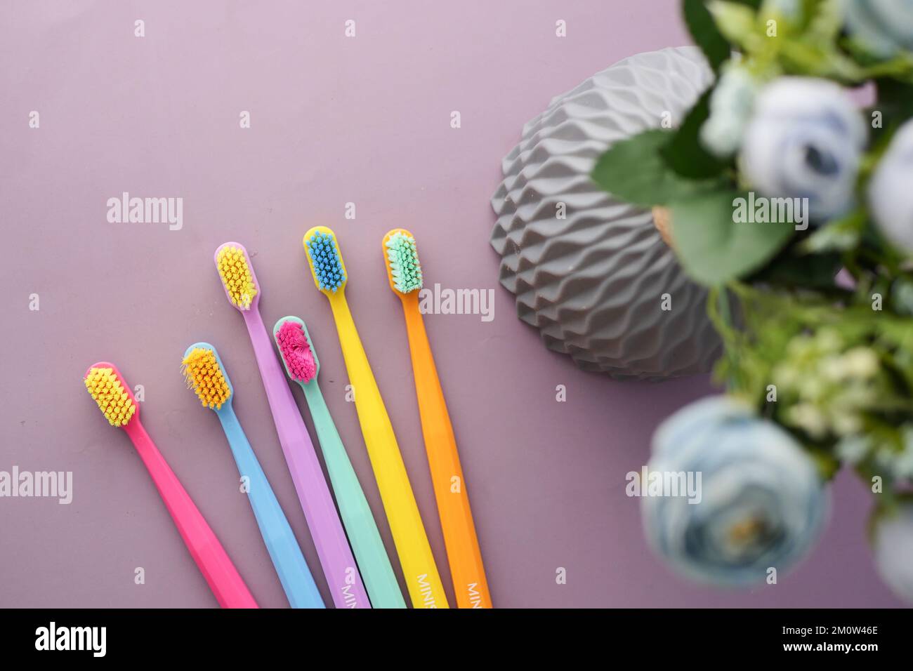 colorful toothbrushes on a purple color background Stock Photo - Alamy