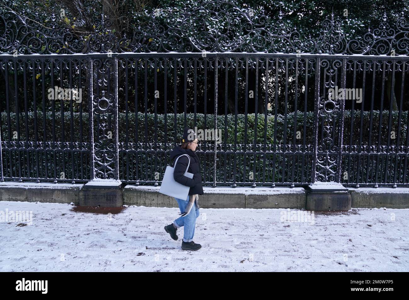 A person walks along a snow covered pavement in Holyrood Park in Edinburgh. The Met Office has issued a number of weather warnings for snow and ice for parts of Scotland, Northern Ireland, Wales and the east coast and south-west England over the coming days. Picture date: Thursday December 8, 2022. Stock Photo