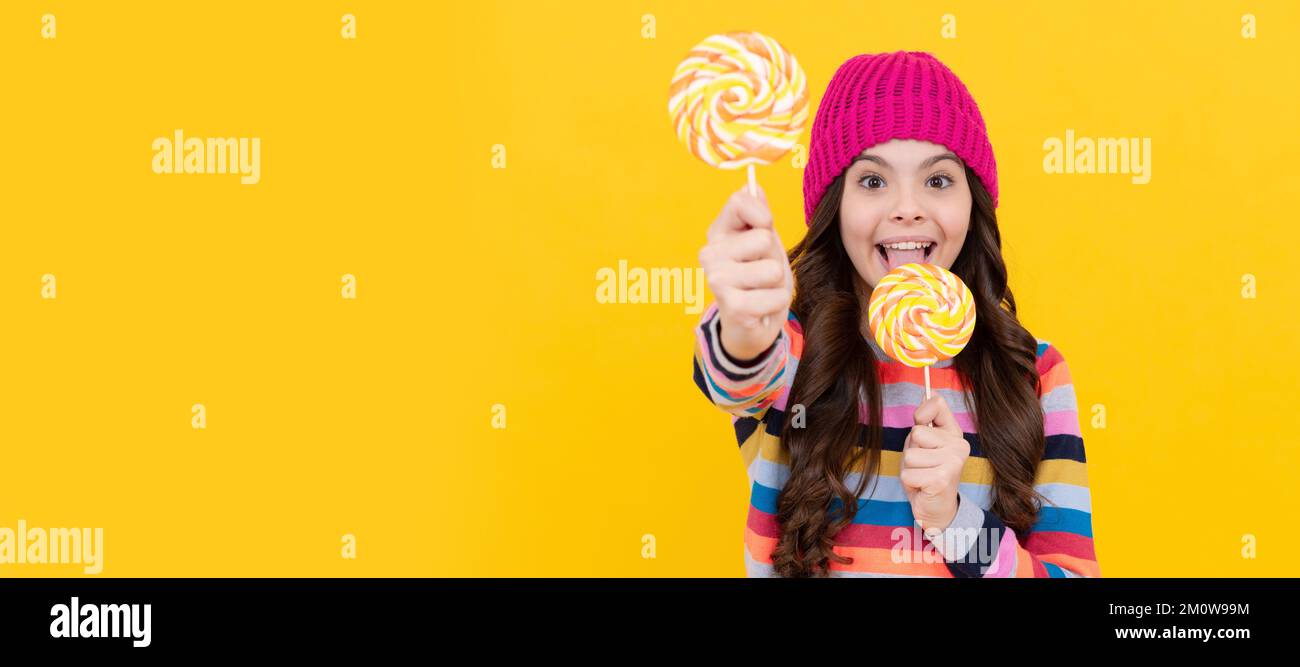 yummy. selective focus. happy teen girl licking lollipop. lollipop lady. kid with colorful lollypop. Teenager child with sweets, poster banner header Stock Photo