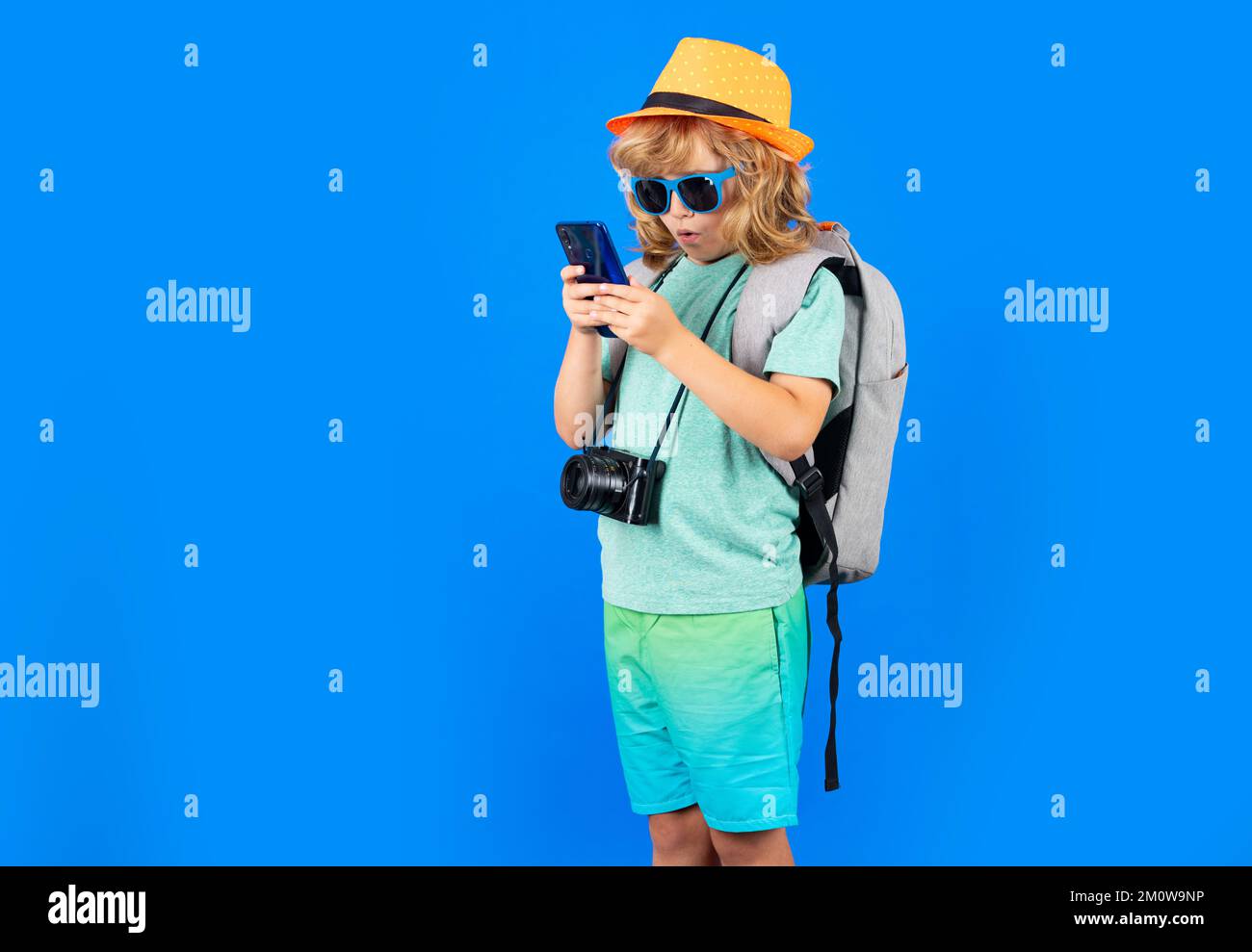 Traveler tourist kid boy 7-8 years old. Kid boy with mobile phone. Stock Photo