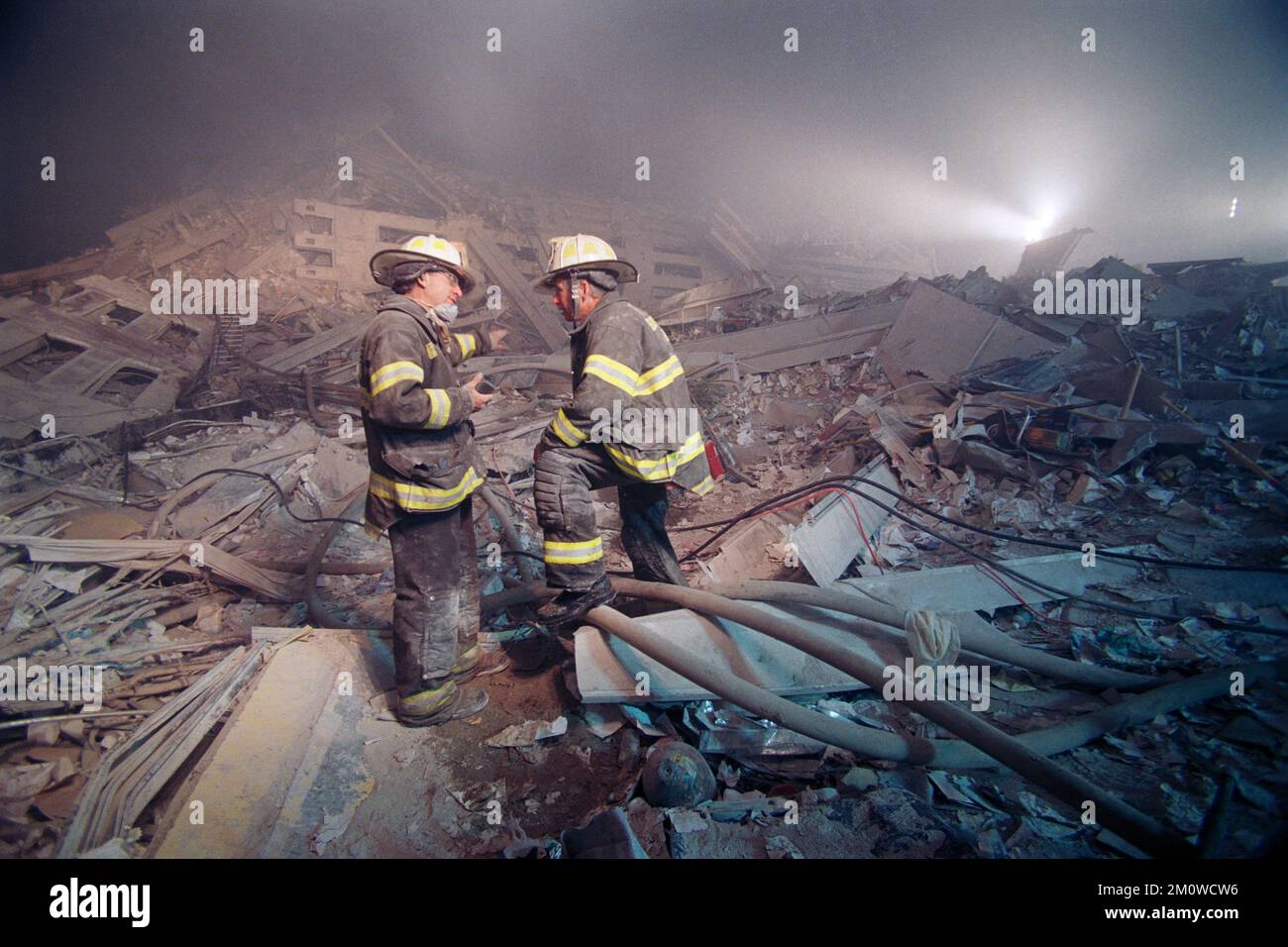 Two New York City Fire Department chiefs stand on the remains of the Twin Towers as they discuss strategy during the night hours following the attack Stock Photo