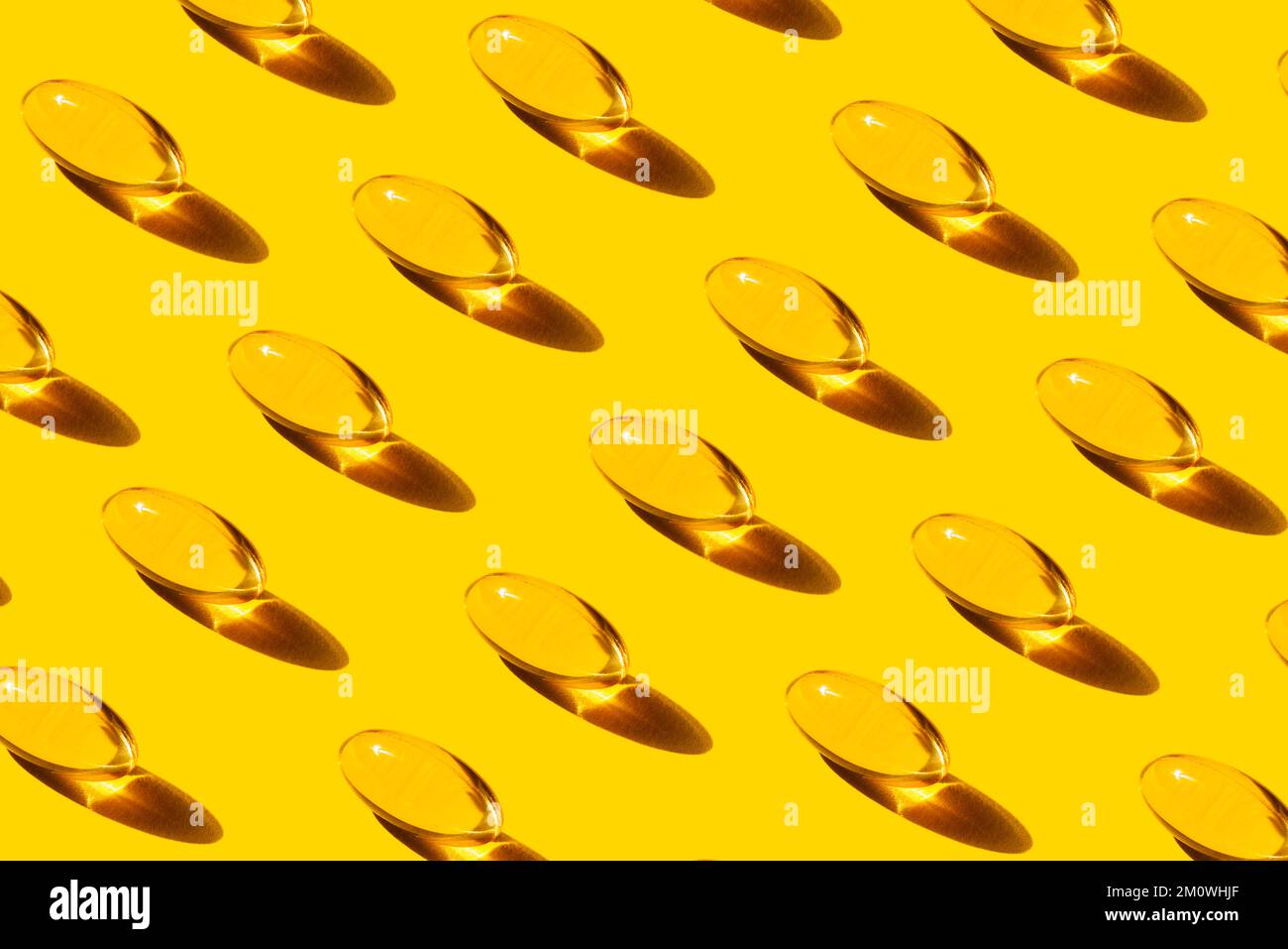 Pop Art Pattern Fish Oil capsules with Omega-3 repetition on Yellow Background studio shot, Taking nutritional supplements and vitamins. Stock Photo