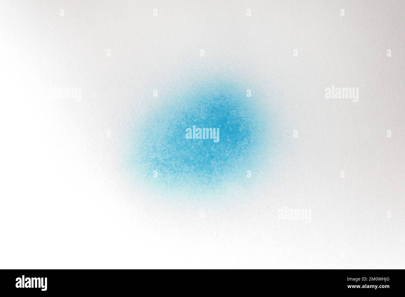a blue spray paint stain on a white paper background Stock Photo Alamy