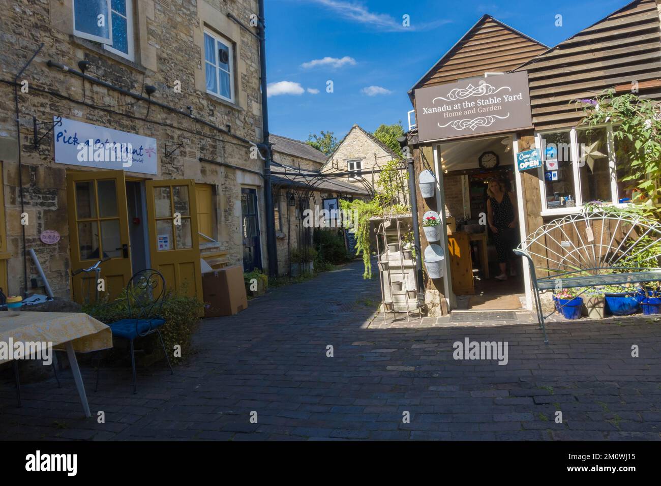 Tucked away just of Black Jack street is Stable Yard with it's quaint little shops and bar. Cirencester England UK. August 2022 Stock Photo